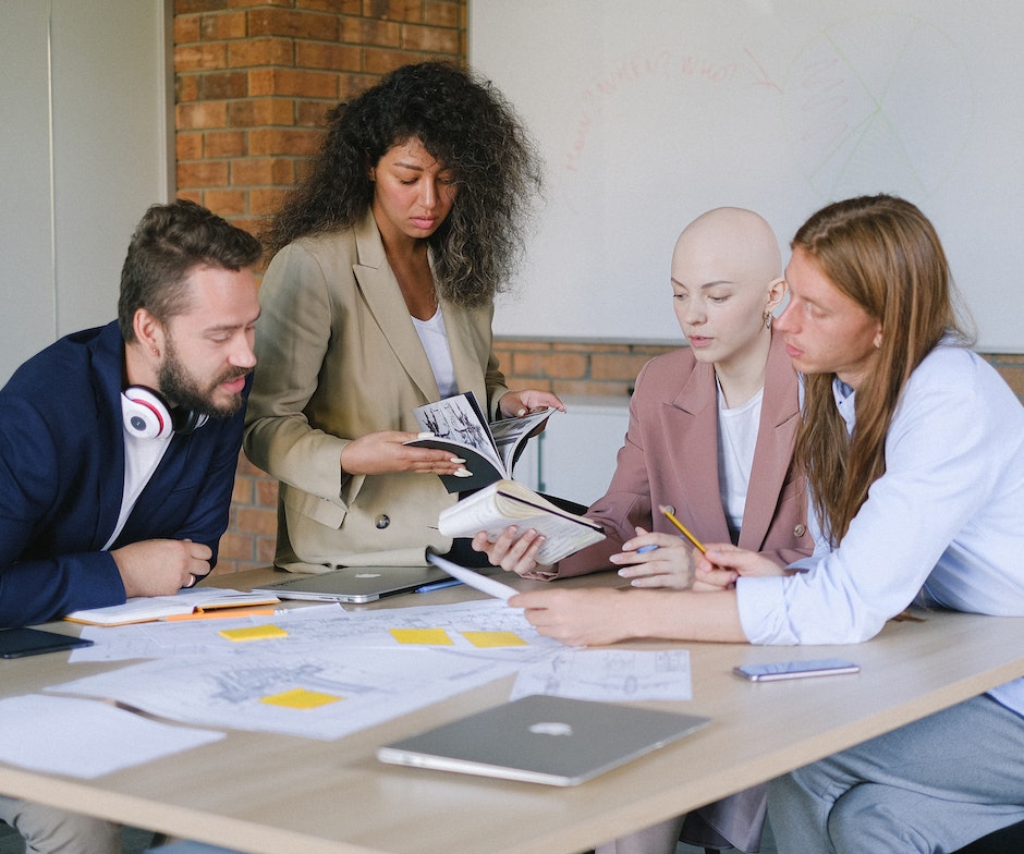 personnes assises autour d'une table discutant et regardant des notes