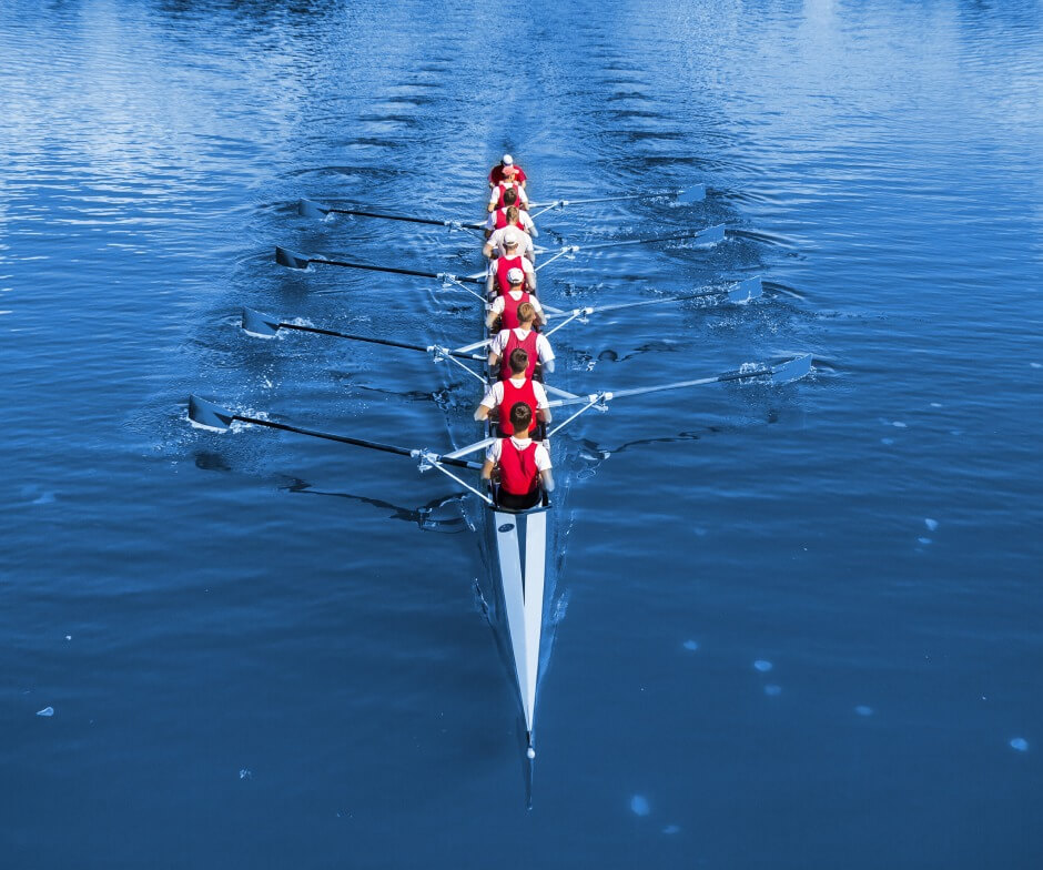 People rowing a boat over a lake