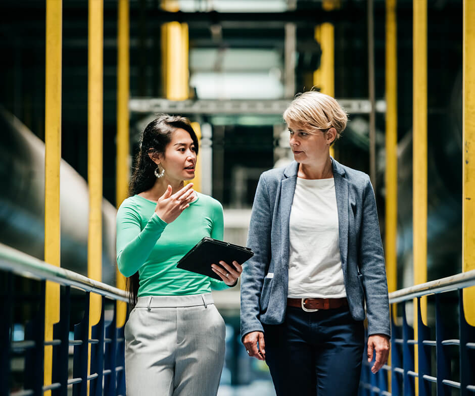 two people walking and talking on a bridge