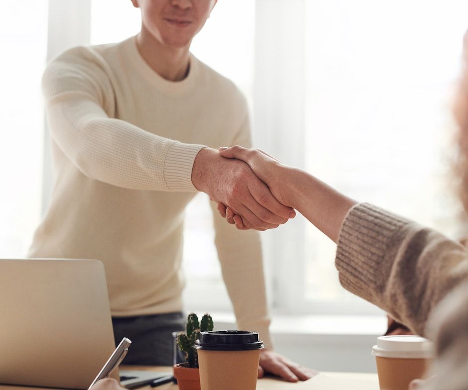 Two people shaking hands in a office