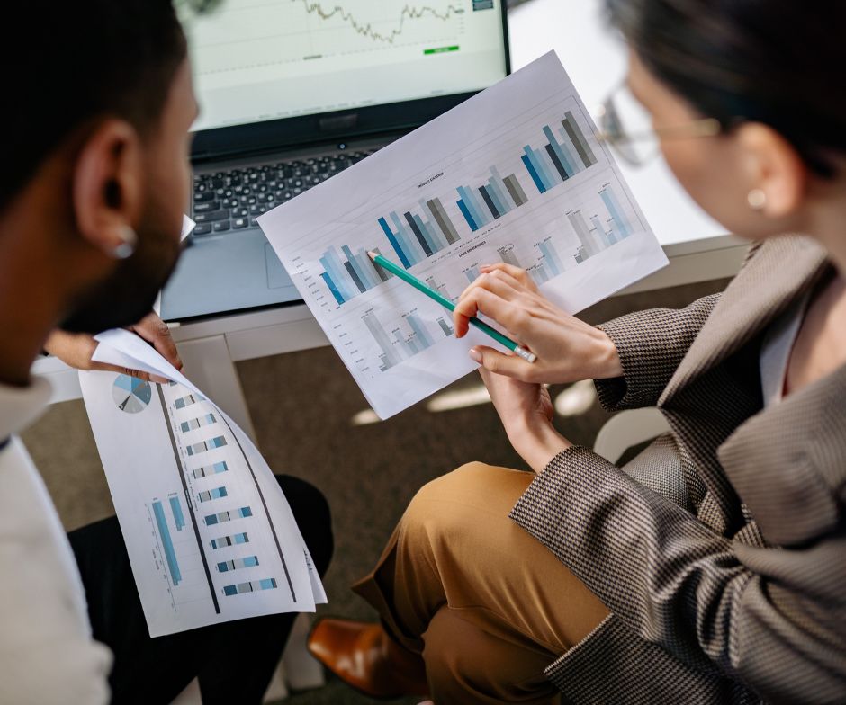 two people talking over graphs in an office