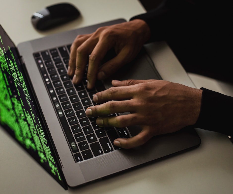 person typing keyboard on laptop and mouse on side